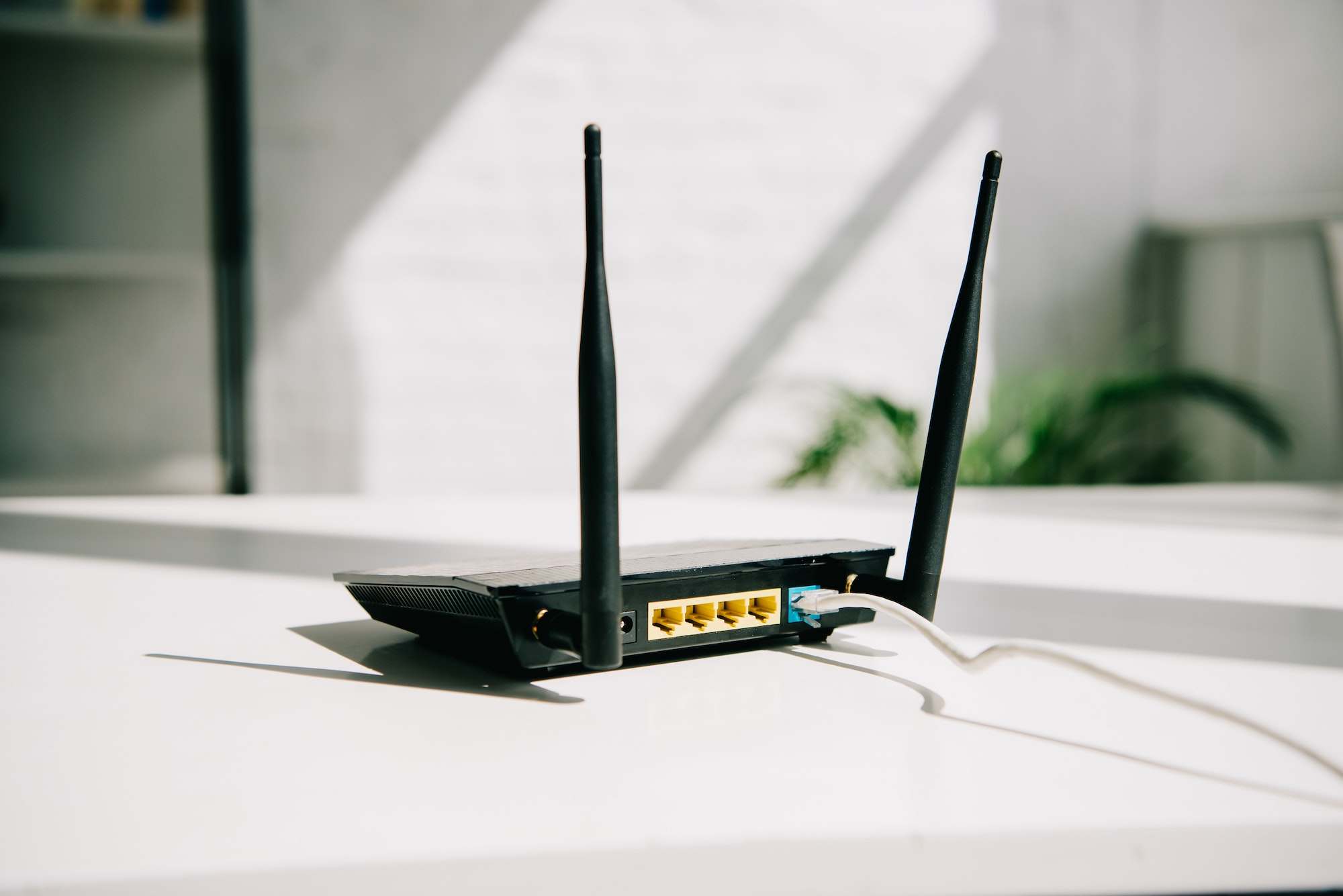 black plugged router on white office table in sunshine