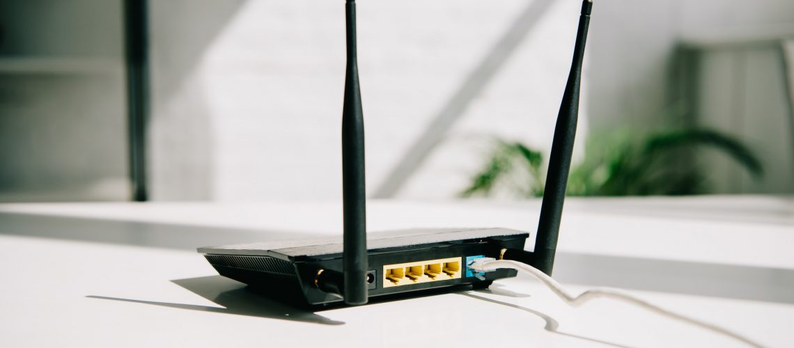 black plugged router on white office table in sunshine