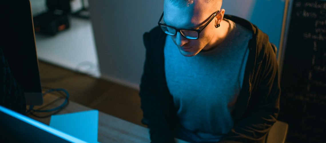 high angle view of hacker developing malware in dark room